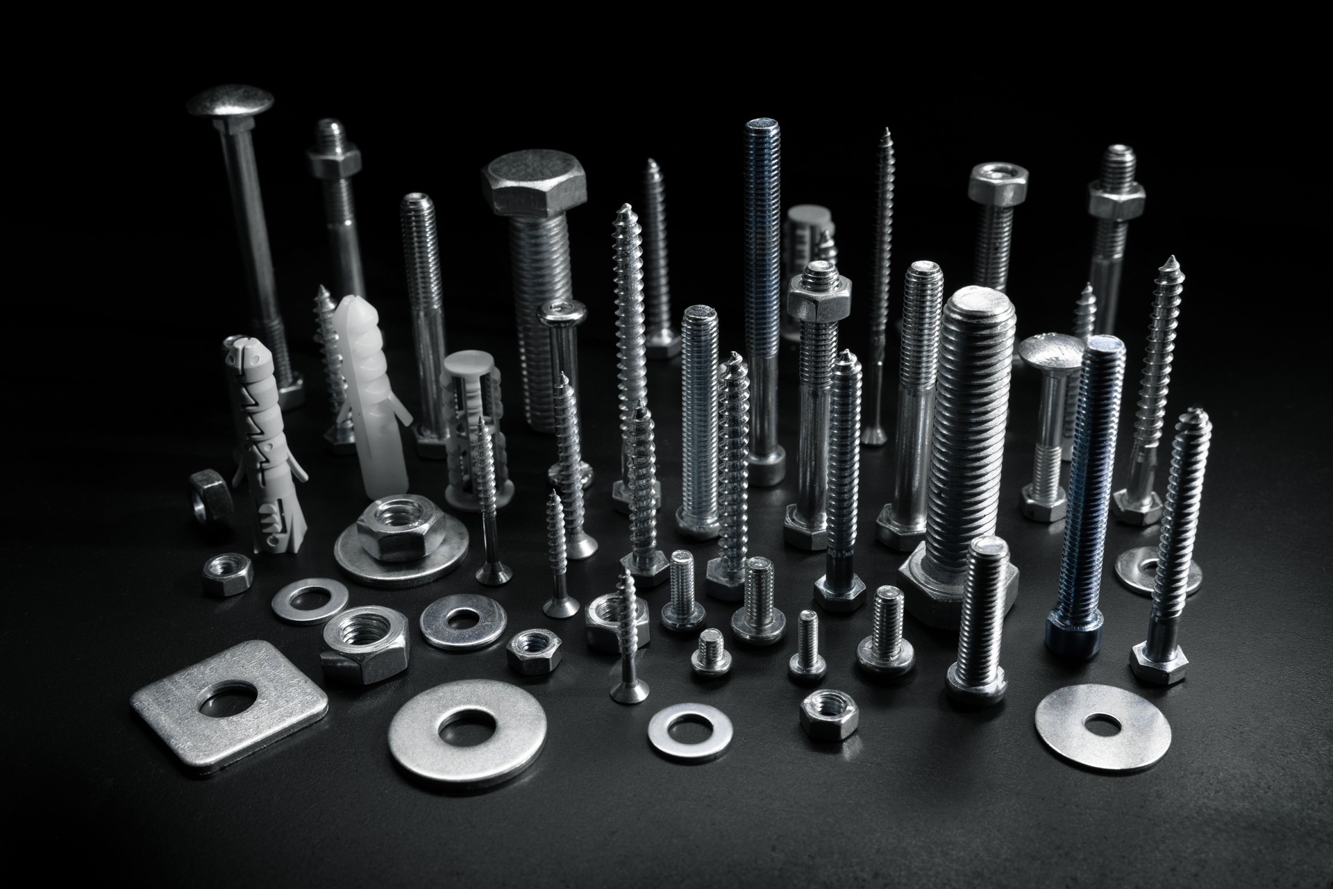 group of various screws, bolts and fasteners on black background